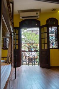 Cet appartement comprend une chambre avec une porte et un balcon. dans l'établissement Tabalo Hostel Hanoi, à Hanoï