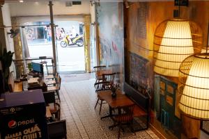 a room with chairs and a table and a lamp at Tabalo Hostel Hanoi in Hanoi