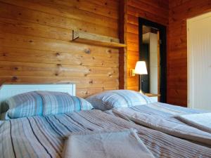 2 camas num quarto com uma parede de madeira em Diemelsee Sudeck - Ein Ferienhäuschen zum WOHLFÜHLEN em Diemelsee