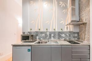 a kitchen with a sink and a microwave at GuestReady - Comendador Sto Ildefonso - D in Porto