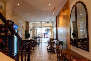 河内Tabalo Hostel Hanoi的有酒吧和桌椅的餐厅