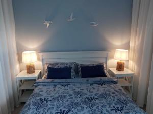 a bedroom with a bed with two lamps on it at Apartament Wyspa Mew - 150 m od plaży in Gąski