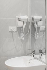 a bathroom with a sink and two hair dryers at Tabalo Hostel Hanoi in Hanoi