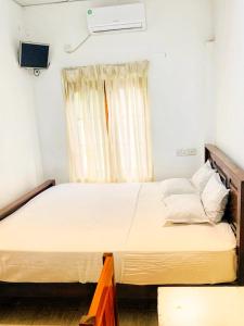 a large bed in a room with a window at Thanamal-villa in Tanamalwila