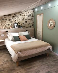ein Schlafzimmer mit einem großen Bett in einem Zimmer in der Unterkunft Le Mas du Martinet in Anduze