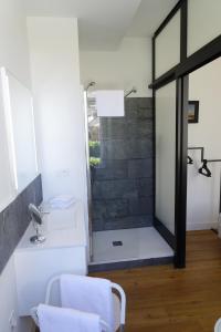 La salle de bains est pourvue d'une douche avec une porte en verre. dans l'établissement Maison Eugénie, à Luchon