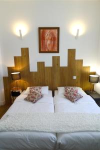 - une chambre avec 2 lits et une photo sur le mur dans l'établissement Maison Eugénie, à Luchon