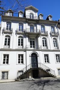 duży biały budynek z mnóstwem okien w obiekcie Maison Eugénie w mieście Luchon