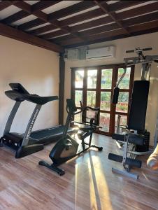 un gimnasio con cintas de correr y bicicletas estáticas en una habitación en บ้านยุ้งฮีลล์รีสอร์ท Baan Yung Hill Resort en Ban Pa Sang