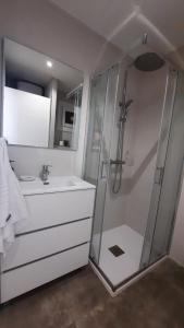 baño blanco con ducha y lavamanos en VibesCoruña-Adelaida 41 en A Coruña
