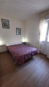 1 dormitorio con 1 cama con colcha roja y ventana en VibesCoruña-Adelaida 41 en A Coruña