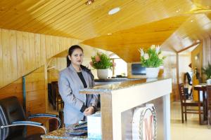 a woman standing at a counter in a restaurant at The Rose, Kasauli -A Four Star Lavish & Luxury Hotel in Kasauli