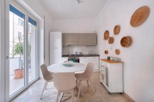 cocina blanca con mesa blanca y sillas en Blue Horizon, en Pescara
