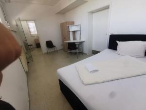 - une chambre avec un lit blanc et un bureau dans l'établissement Einzelbettzimmer in Ramstein, à Ramstein-Miesenbach