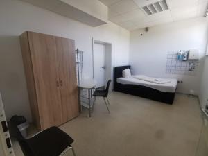 Cette chambre comprend un lit, un bureau et une chaise. dans l'établissement Einzelbettzimmer in Ramstein, à Ramstein-Miesenbach
