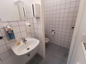 a white bathroom with a sink and a toilet at Einzelbettzimmer in Ramstein in Ramstein-Miesenbach