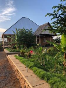 dom z drogą przed nim w obiekcie Jua Manyara Lodge & Camp Site w Mto wa Mbu