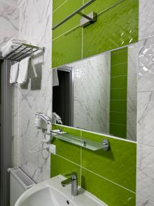 uma casa de banho com um lavatório e um espelho em Maestro em Ostroh