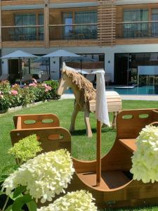 斯圖姆的住宿－Natur Resort RISSBACHER，长颈鹿坐在长凳上的雕像