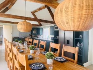 a dining room with a long table and chairs at Broadway House, 7 Bedroom, 6 Baths in Cheltenham