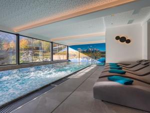 una piscina con sofá en una habitación con ventanas en Gasthof zur Post en Hinterriss