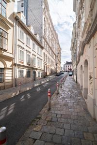 una calle adoquinada con una fila de postes rojos y blancos en Cozy Central Flat Spittelberg, en Viena