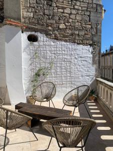 two chairs and a wooden bench on a patio at Penthouse Apartment with Large Terrace and Veranda in Arles