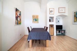 una sala da pranzo con tavolo, sedie e dipinti di Cozy Central Flat Spittelberg a Vienna