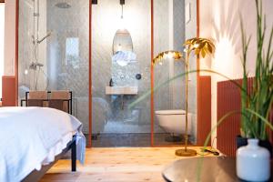 a bedroom with a bed and a bathroom with a toilet at TREMONDI - Boutique BnB in Quarten +24 photos