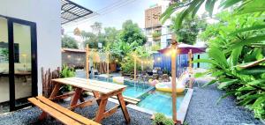 um quintal com uma piscina, uma mesa e um baloiço em Villa 68 4BR FREE PICK-UP AIRPORT & BILLIARDS CLOSE TO MY KHE BEACH em Da Nang
