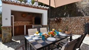 una mesa con comida y bebida en el patio en Cortijo en Frigiliana, en Frigiliana