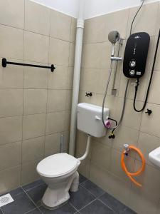 a bathroom with a toilet and a shower at Arifz Zai Homestay in Batu Kurau