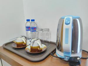 a toaster and two plates of food and bottles of water at TELUK PENYABUNG RESORT in Kampung Mawar