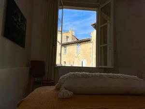 a bedroom with a window with a view of a building at Penthouse Apartment with Large Terrace and Veranda in Arles