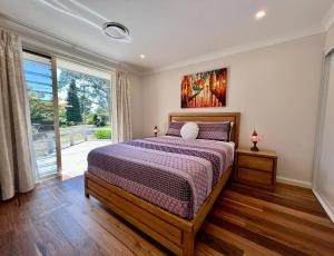 a bedroom with a bed and a large window at Birdwood Guesthouse in Blackheath