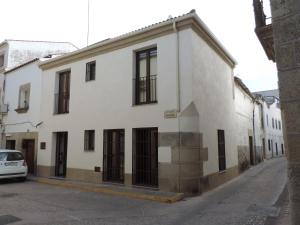 un edificio blanco con ventanas negras en una calle en Cuadrina Barbancho in Casar de Caceres, en Casar de Cáceres