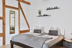 Schlafzimmer mit einem Bett und einem Spiegel in der Unterkunft Zur Alten Schmiede in Stralsund