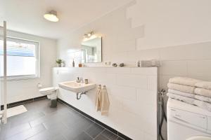 ein weißes Bad mit einem Waschbecken und einem WC in der Unterkunft Zur Alten Schmiede in Stralsund