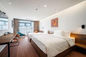 Habitación de hotel con cama grande y escritorio. en Hotel Cielo, en Siheung