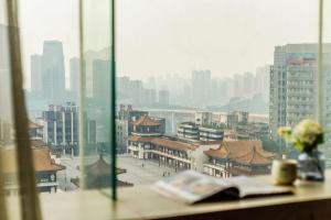 een raam met uitzicht op een stad met gebouwen bij Heye International Youth Hostel in Chongqing