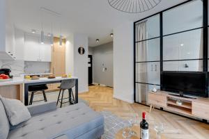 a living room and kitchen with a couch and a tv at Apartments Doki by TriApart in Gdańsk