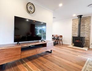 a living room with a tv and a fireplace at Birdwood Guesthouse in Blackheath