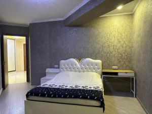 een slaapkamer met een wit bed en een bureau bij khiliani in Tbilisi City