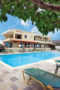 a hotel with a swimming pool in front of a building at Gefyra Rooms in Ancient Epidauros