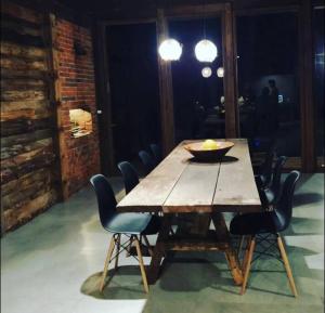 a wooden table with chairs and a bowl on it at Guajuvira House Casa de Campo in Araucária