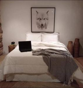 ein Schlafzimmer mit einem Bett und einem Laptop darauf in der Unterkunft Guajuvira House Casa de Campo in Araucária