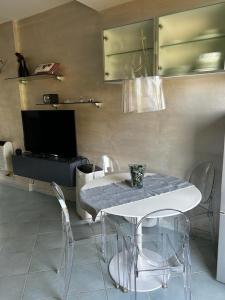 a dining room with a table and chairs and a tv at Dedelollo’s Home in Sanremo