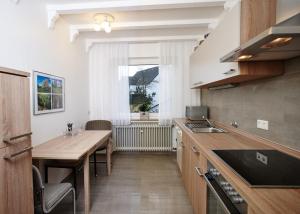 a kitchen with a table and a sink and a window at Ferienwohnung Stölben in Daun