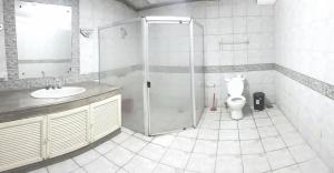 ein Bad mit einer Dusche und einem WC in der Unterkunft White House, Batangas in Lian