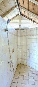 een badkamer met een douche in een betegelde kamer bij White House, Batangas in Lian